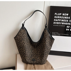 Detail view of large leopard print hobo bag with black leather strap and textured fabric