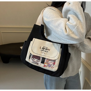 Detail of canvas tote bag with black body, cream flap, and transparent PVC cartoon pocket