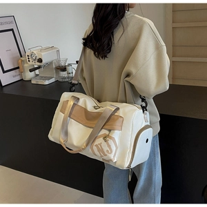 Détail d'un sac de sport blanc avec sangles marron et poche latérale pour le rangement
