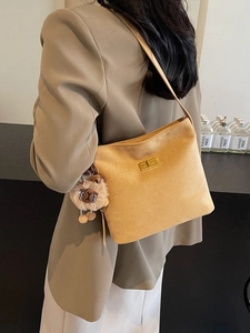 Yellow suede shoulder bucket bag with gold clasp and brown teddy bear charm