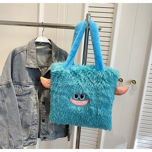 Détail d'un sac cabas monstre bleu en peluche avec broderie et cornes colorées douces