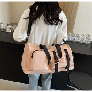 Détail d'un grand sac de voyage rose avec sangles réglables et poches de rangement latérales