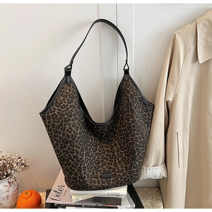 Close-up of leopard print tote bag with black leather trim and rectangular logo patch