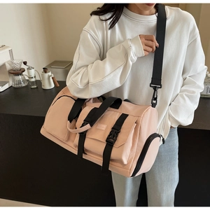 Vue détaillée du sac de sport rose clair avec sangles noires et boucles en décor réel