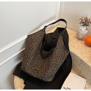 Detail view of leopard print tote bag showing soft hobo silhouette and black shoulder strap
