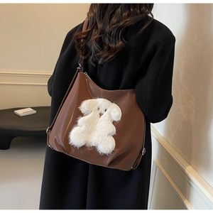 Brown tote bag with large plush dog patch shown in a casual lifestyle setting