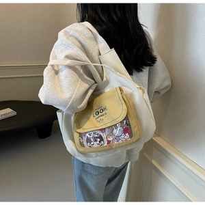 Detail view of large canvas tote bag with transparent front pocket and wide strap