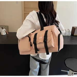 Vue détaillée du sac de voyage rose avec plusieurs poches et bandoulière réglable