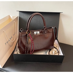 Détail d'un sac à main vintage marron foncé avec fermoir en métal argenté poli
