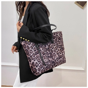 Close-up of leopard print tote bag with black leather handles for winter fashion