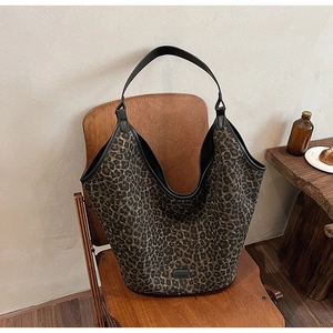 Close-up of leopard print canvas hobo bag on a chair with warm vintage lighting