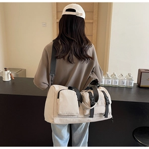 Vue arrière d'un sac de sport beige avec sangles noires dans un café au style épuré