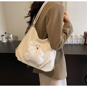 Detail view of large white canvas tote bag featuring cute plush bear applique embroidery