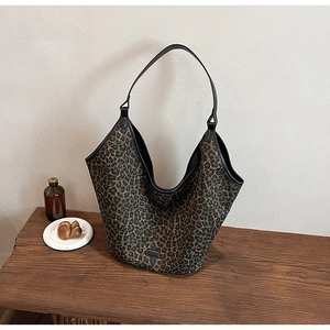 Chic leopard print hobo bag with large capacity shown on a vintage wooden table detail
