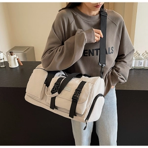 Détails du sac de sport beige avec plusieurs poches pratiques et sangles tissées