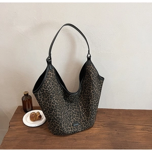 Large leopard print hobo bag on a rustic wooden table for a vintage lifestyle look
