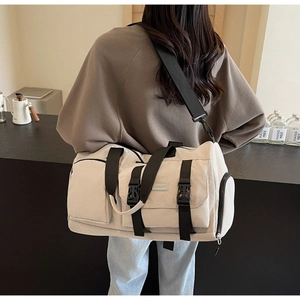Sac de voyage beige à poches multiples porté par un mannequin, grande capacité et style