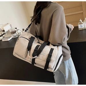 Vue détaillée du grand sac de sport beige avec bandoulière et poche latérale