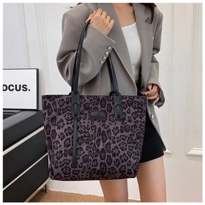 Detail of spacious leopard print tote bag with black leather shoulder straps