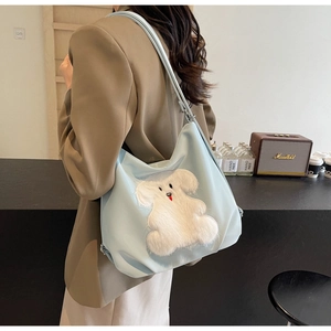 Close-up of light blue casual tote bag featuring a cute white plush animal patch
