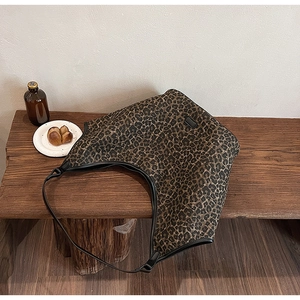 Leopard print tote bag displayed on a wooden bench in a lifestyle afternoon tea setting