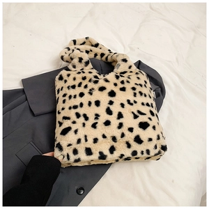 Détail d'un sac à main en peluche moucheté sur un blazer gris pour le style hivernal