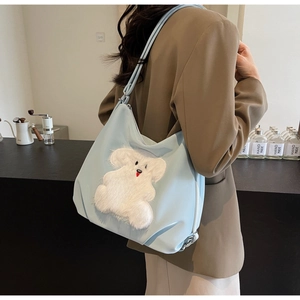 Close-up of light blue tote bag featuring a 3D white plush puppy pattern on fabric