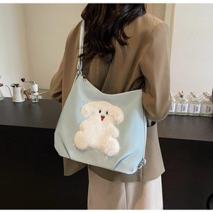 Rear view of a model wearing the light blue waterproof nylon tote with cartoon patch