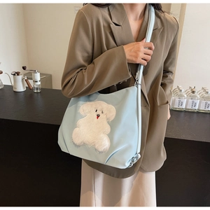 Detail of light blue cute puppy tote bag with white plush dog patch for daily commute