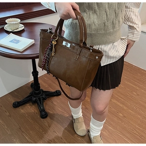 Gros plan sur la texture du cuir PU marron et l'ornement foulard sur le sac à main