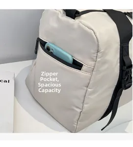 Detail view of the side zipper pocket on a beige travel bag holding a smartphone