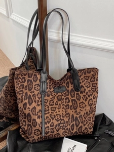 Chic leopard print tote bag with black leather straps and fashion label in mirror shot