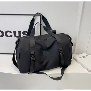 Close-up of black waterproof travel bag with logo detail and adjustable shoulder straps