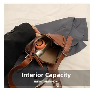 Detail view of the brown leather shoulder bag internal capacity and soft fabric lining