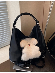 Black glossy leather tote bag with white plush animal patch and shoulder strap
