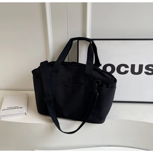 Close-up of black nylon fitness tote with Ninquia embroidery and side pockets