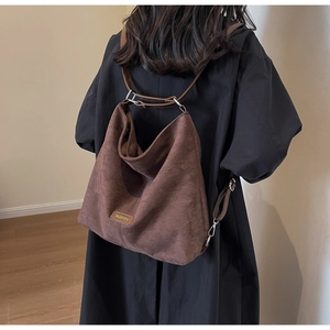 Detail of dark brown matte suede tote bag showing multi-way adjustable shoulder straps