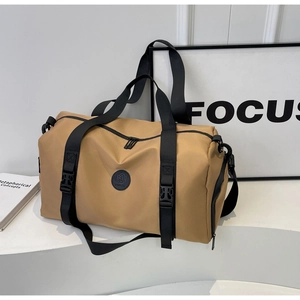 Close-up of khaki waterproof travel bag with black straps and sturdy buckle details