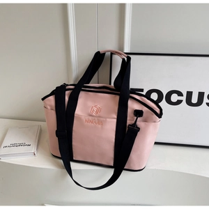 Detailed view of pink yoga tote bag with black strap and embroidered logo design
