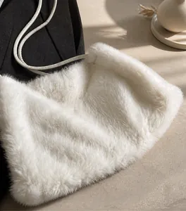 Detail of white faux rabbit fur texture and slim leather shoulder strap on a plush bag