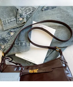 Detail of dark brown retro shoulder bag with adjustable strap and blue card holder