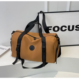 Detail view of mustard yellow travel bag with sturdy black webbing and buckle closures