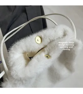 Detail of magnetic gold clasp closure on white faux fur shoulder bag with leather strap
