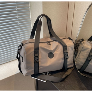 Detail of khaki nylon travel bag showing durable handles and adjustable shoulder strap