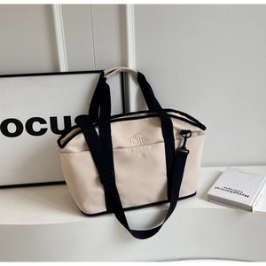 Detail of beige nylon fitness bag showing NINGJIA logo and adjustable black shoulder straps