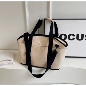 Detail of beige yoga tote bag showing black handles and embroidered NINGJIA logo