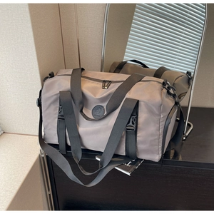 Detail of taupe nylon travel bag with reinforced straps and secure side buckle
