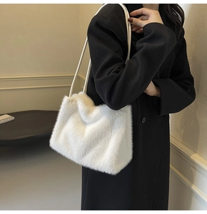 Close-up of white plush shoulder bag in faux fur with elegant dual slim straps for winter