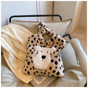 Détail du sac en fausse fourrure léopard avec un écusson de chiot en peluche blanc
