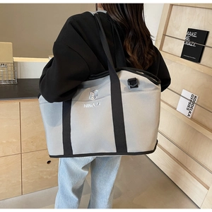 Close-up of grey canvas yoga tote bag with Ningjia logo embroidery and black straps
